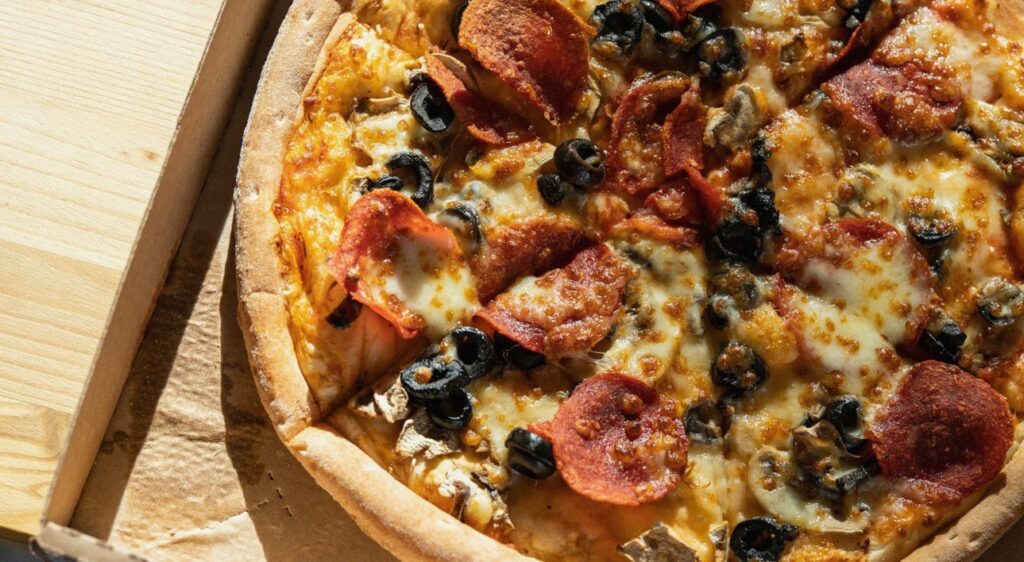 Pizza w kartonie na stole, taka jak z zamówienia na dowóz